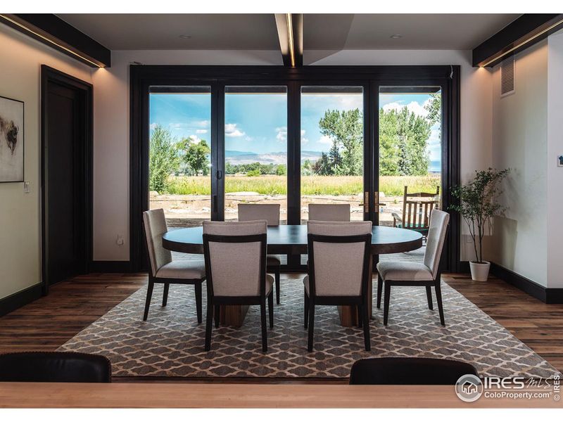 Dinning area with front range view and large accordion doors. Custom steel beams with LED accent lighting