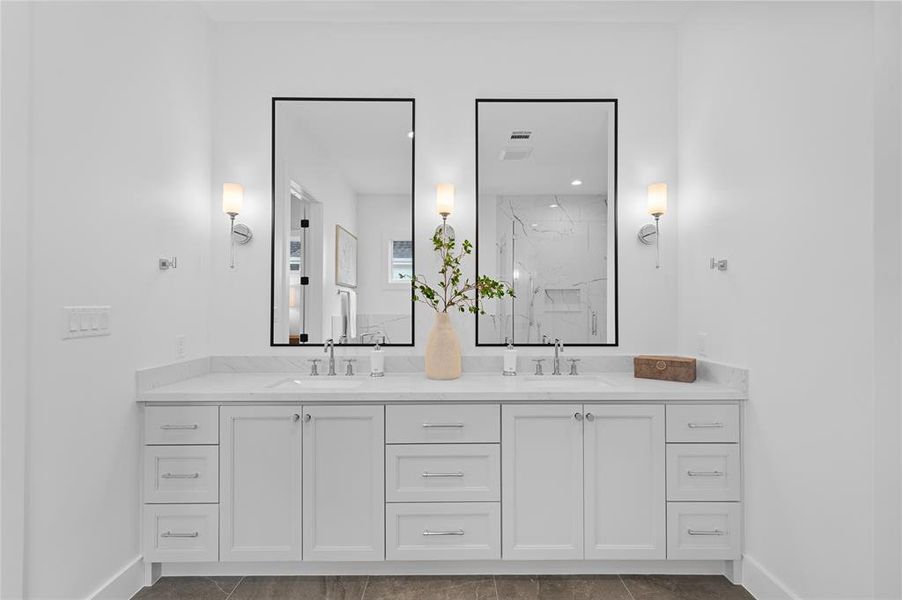 Spacious primary bath with custom built vanity and Kohler plumbing fixtures.