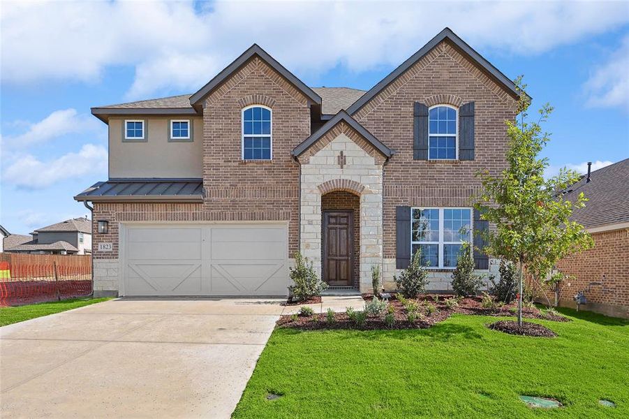 View of front of property with a garage and a front lawn