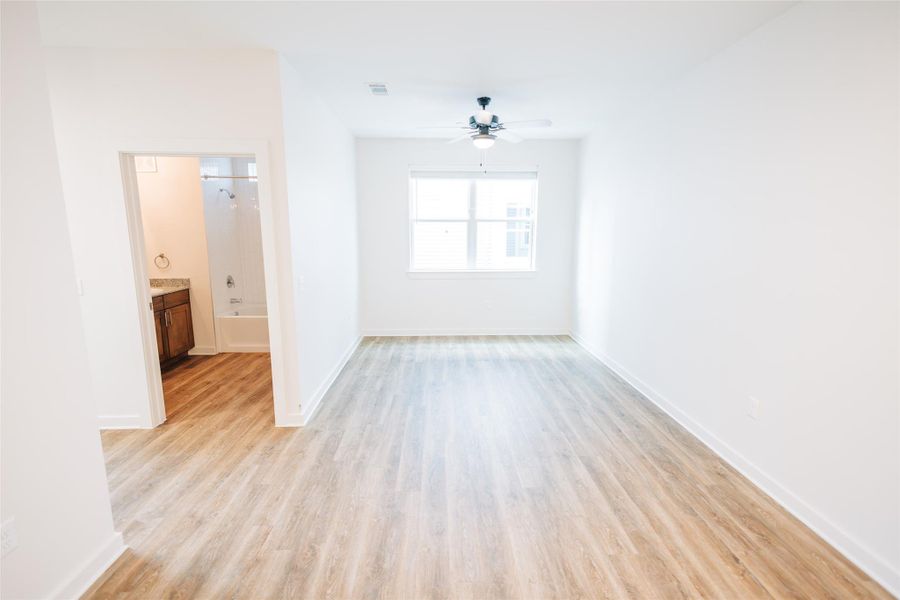 Living room featuring ceiling fan, light wood finished floors, and baseboards