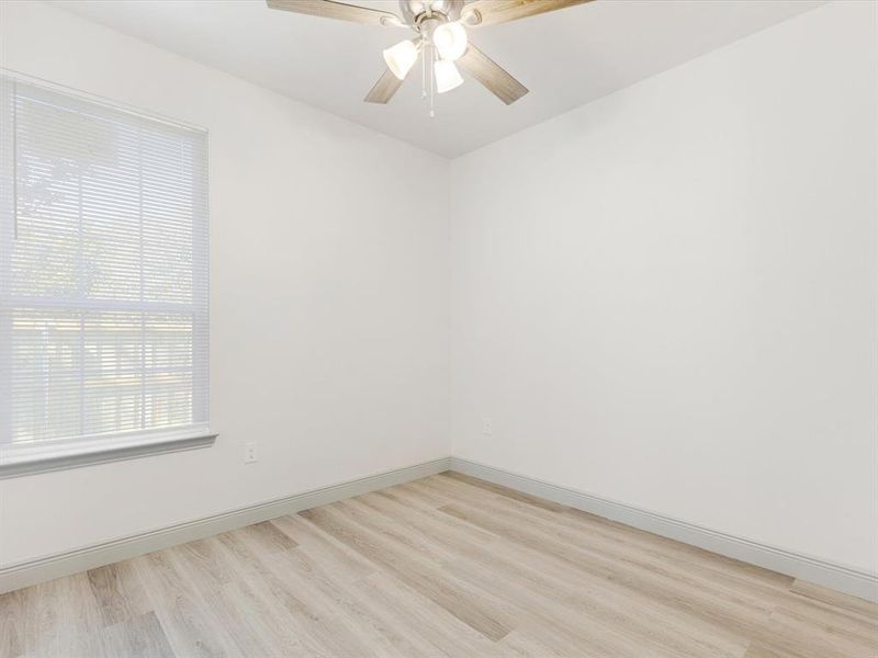 Spare room featuring light wood-style flooring and ceiling fan