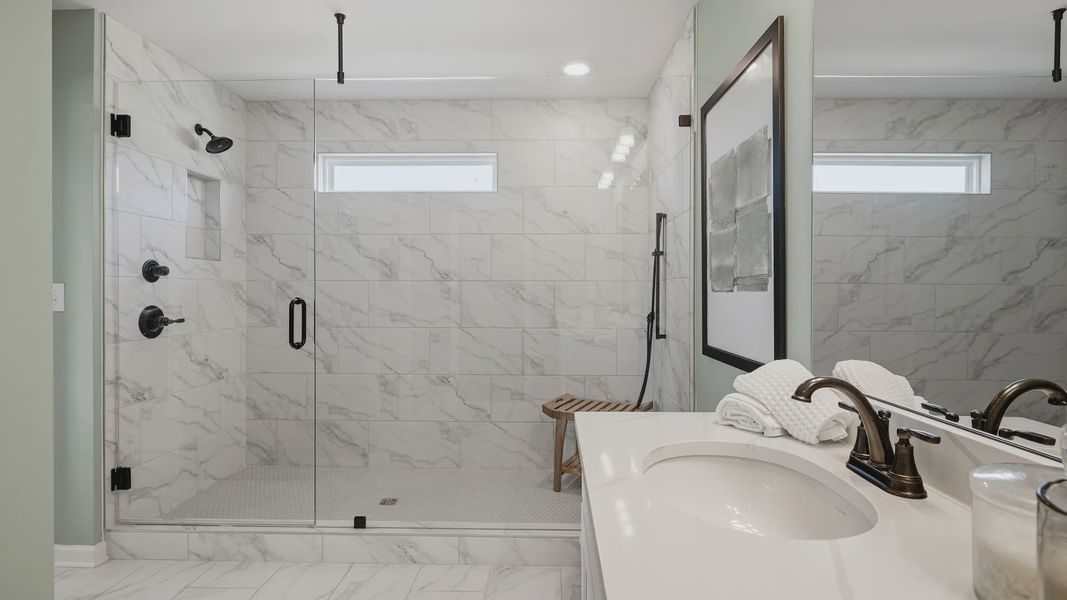 Tile walk-in shower with glass enclosure and modern fixtures in primary bathroom of townhome in Loganville, GA. Tile walk-in shower with glass enclosure and modern fixtures in primary bathroom of townhome in Loganville, GA.