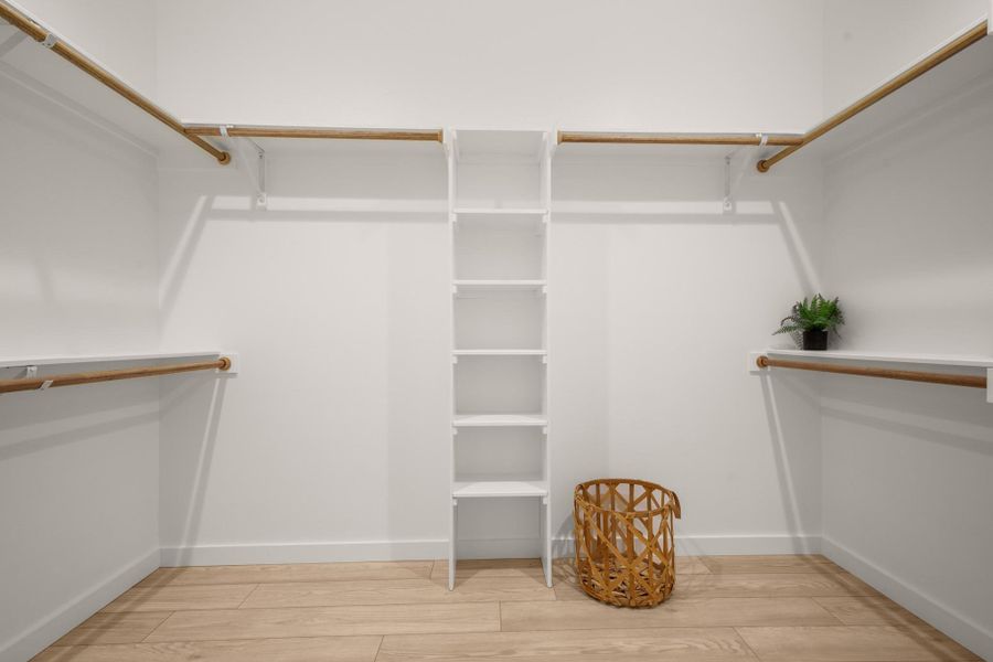 Walk in closet with light wood-type flooring