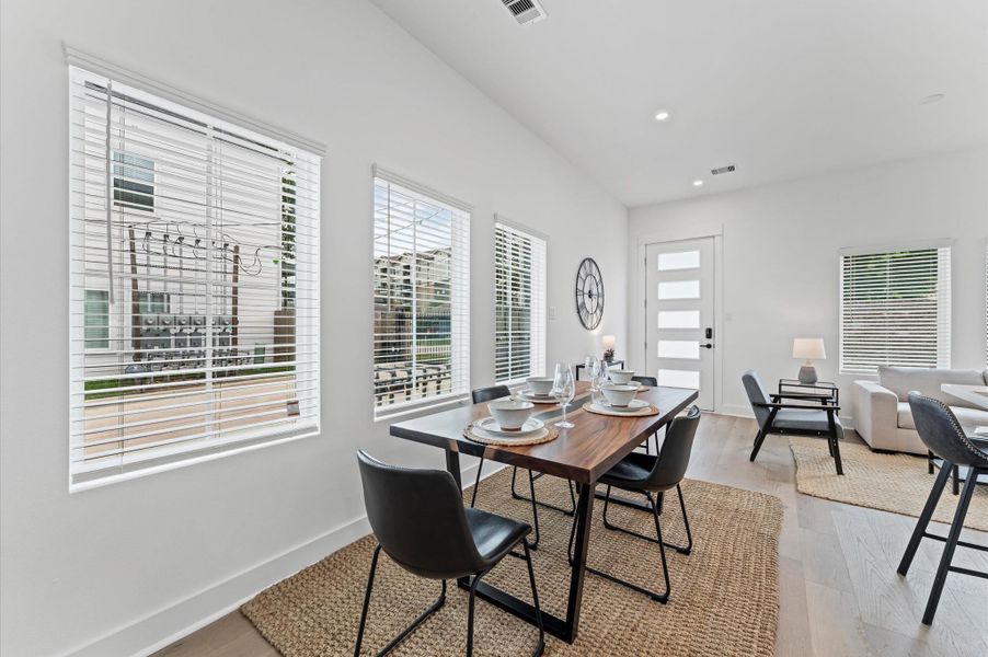 This beautifully designed dining area offers ample space for a full-size dining table, making it ideal for hosting gatherings or enjoying everyday meals in comfort. Surrounded by large windows, the room is bathed in natural light throughout the day, creating a warm and inviting atmosphere. Its seamless integration with the open-concept kitchen and living space enhances flow and functionality, while offering picturesque views and a sense of connection to the outdoors.