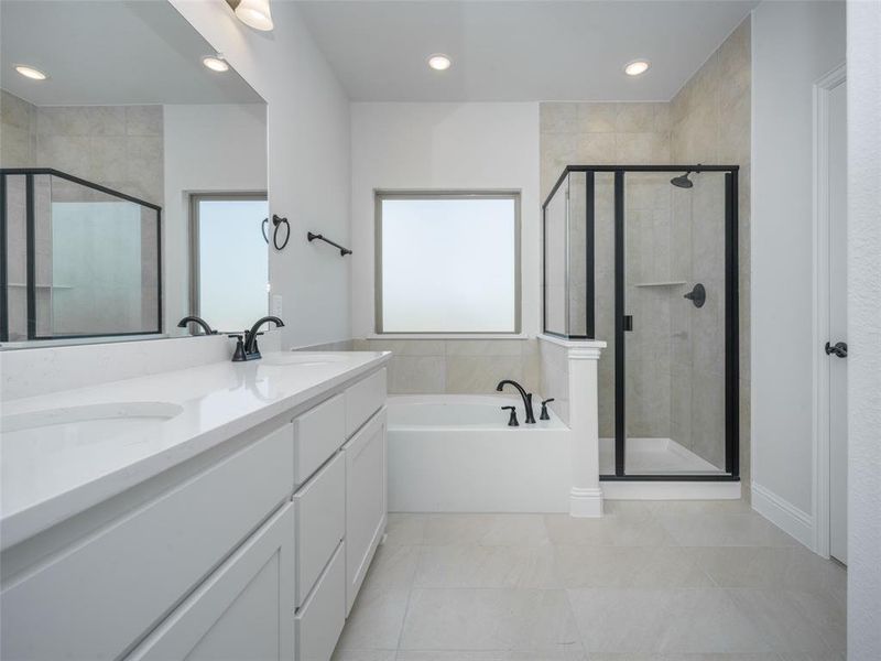 Bathroom with a bath, a shower stall, double vanity, light tile patterned floors, and recessed lighting Bathroom with a bath, a shower stall, double vanity, light tile patterned floors, and recessed lighting