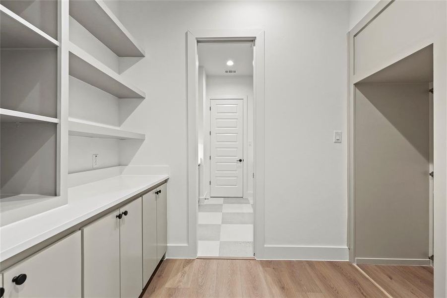 Laundry area featuring light wood-style floors and baseboards Laundry area featuring light wood-style floors and baseboards