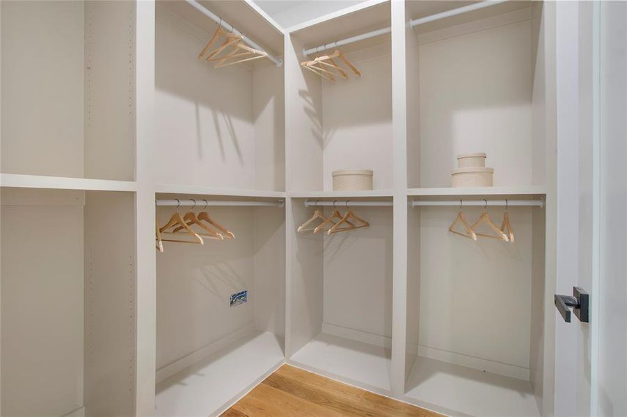 Walk in closet with wood-type flooring