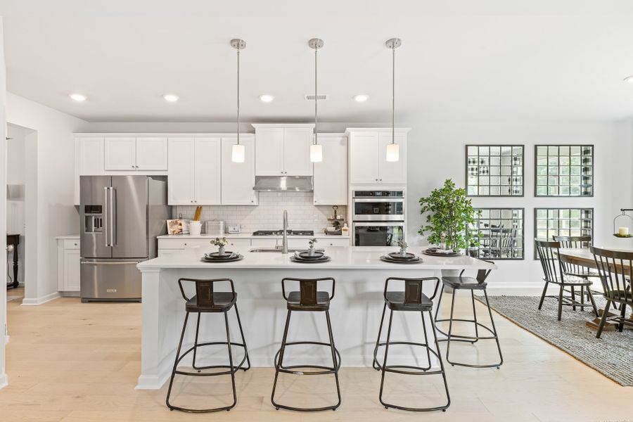 A kitchen with a table and chairs.