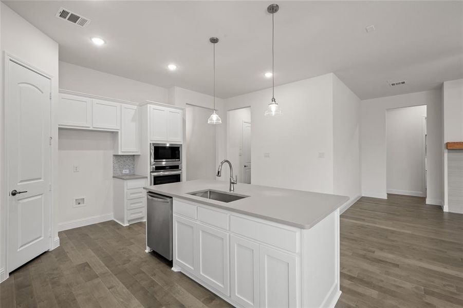 Kitchen with stainless steel appliances, a sink, dark wood-style flooring, white cabinetry, and recessed lighting Kitchen with stainless steel appliances, a sink, dark wood-style flooring, white cabinetry, and recessed lighting
