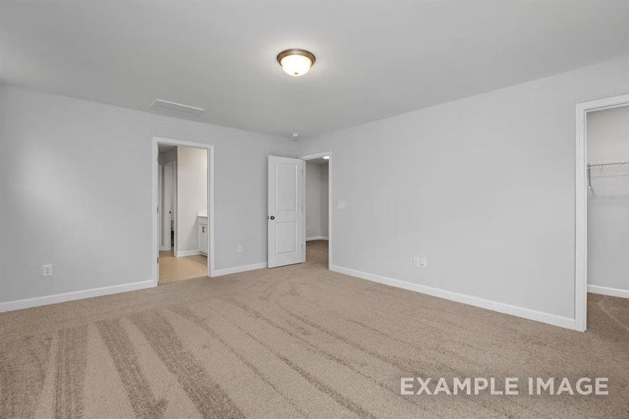 Unfurnished bedroom featuring connected bathroom, a spacious closet, a closet, and carpet