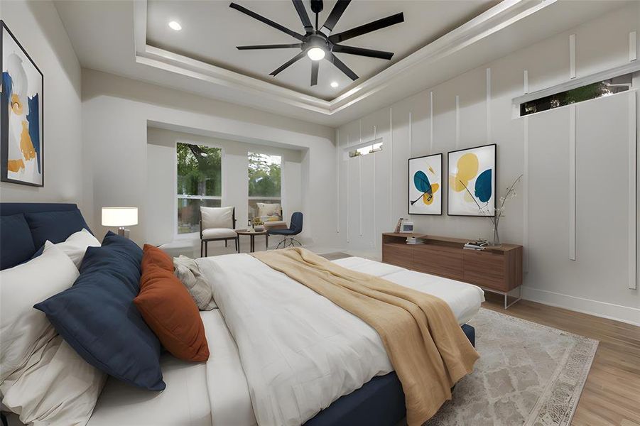 Bedroom featuring light hardwood / wood-style floors, ceiling fan, and a raised ceiling