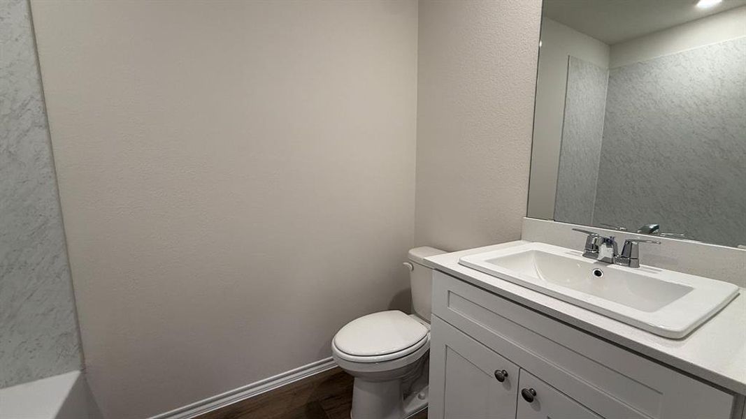 Bathroom featuring a white vanity with an integrated sink, polished chrome faucet, and a large wall-mounted mirror