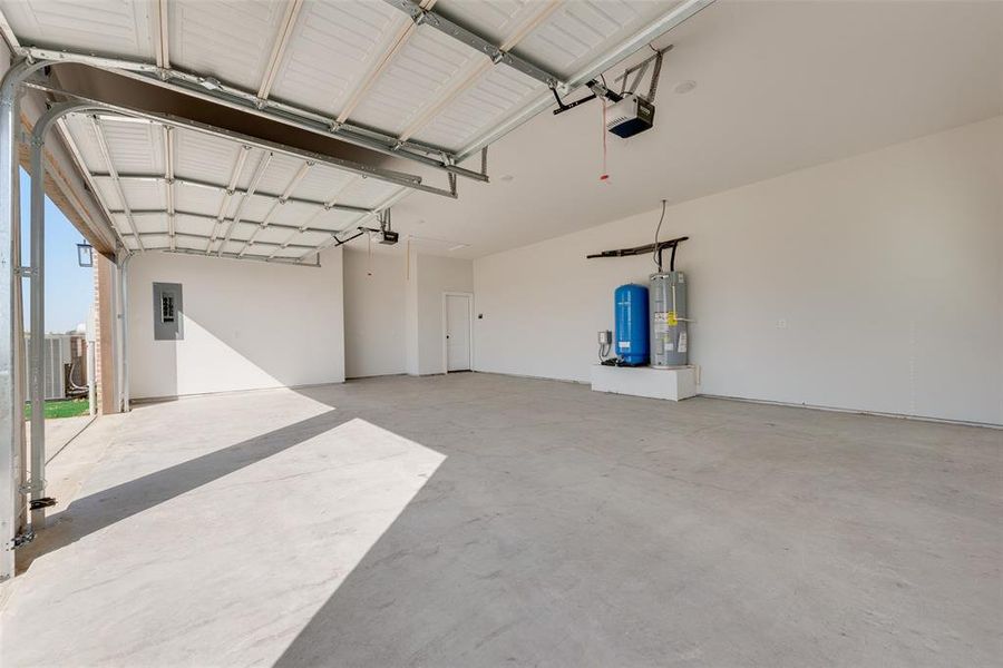 Garage with central AC unit, a garage door opener, electric panel, and water heater