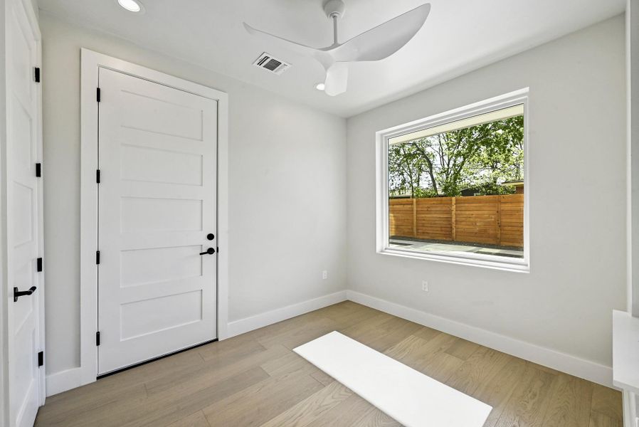 1st Floor Secondary Bedroom with tons of natural light. (This is Unit #2 - each Unit has the same layout, however a few differing details such as light fixtures, custom cabinet/backsplash/tile colors)