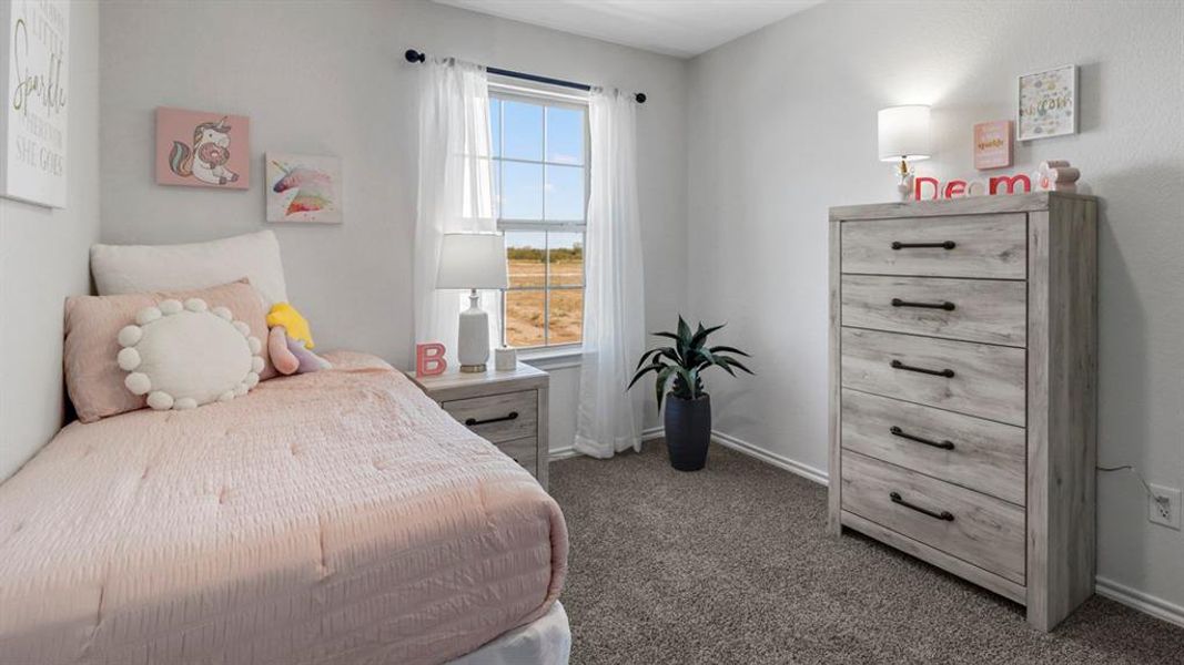 Bedroom with dark carpet and baseboards