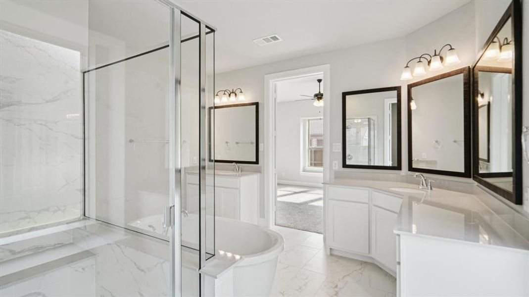 Full bathroom featuring a marble finish shower, two vanities, a soaking tub, light marble finish floors, and a ceiling fan Full bathroom featuring a marble finish shower, two vanities, a soaking tub, light marble finish floors, and a ceiling fan
