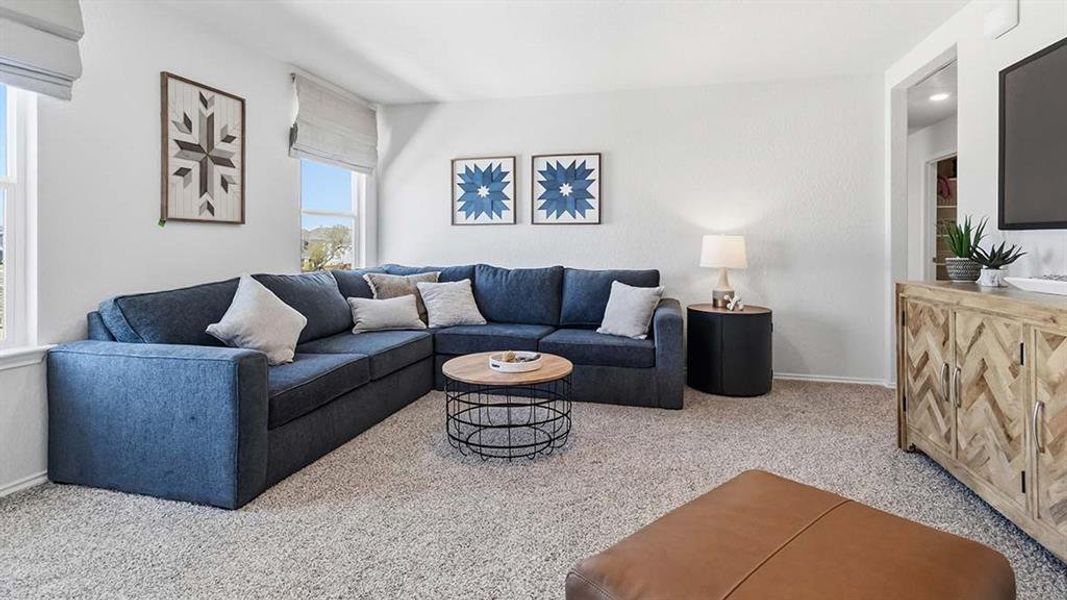 Spacious living area featuring light neutral wall paint and plush carpet flooring