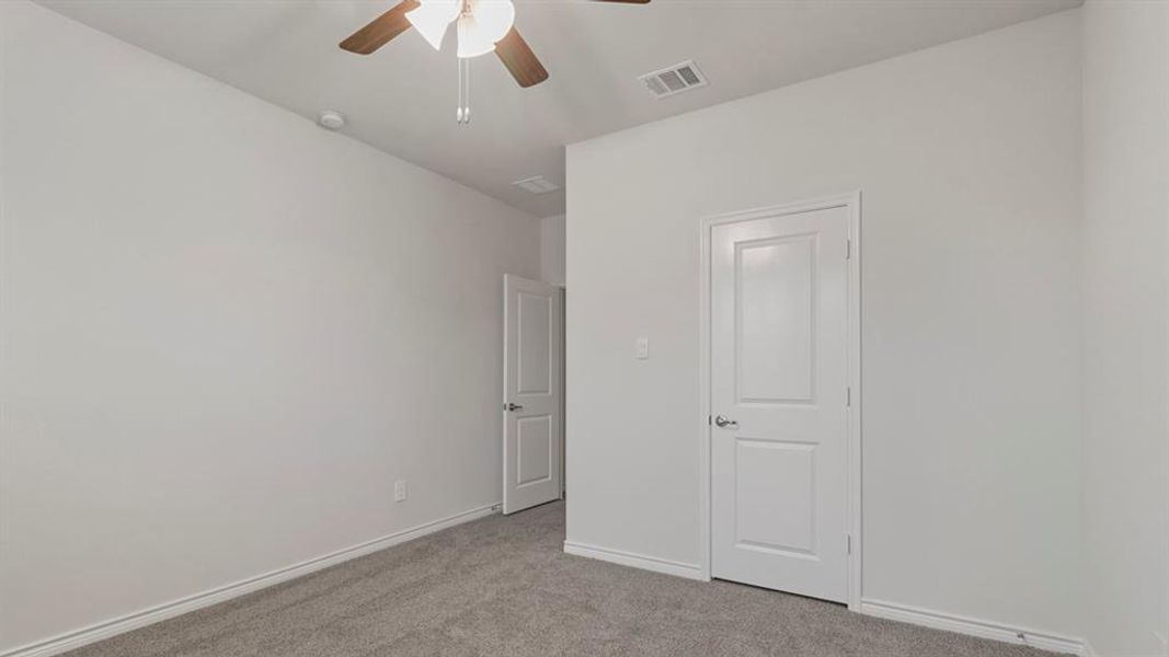 Unfurnished bedroom featuring light colored carpet and ceiling fan