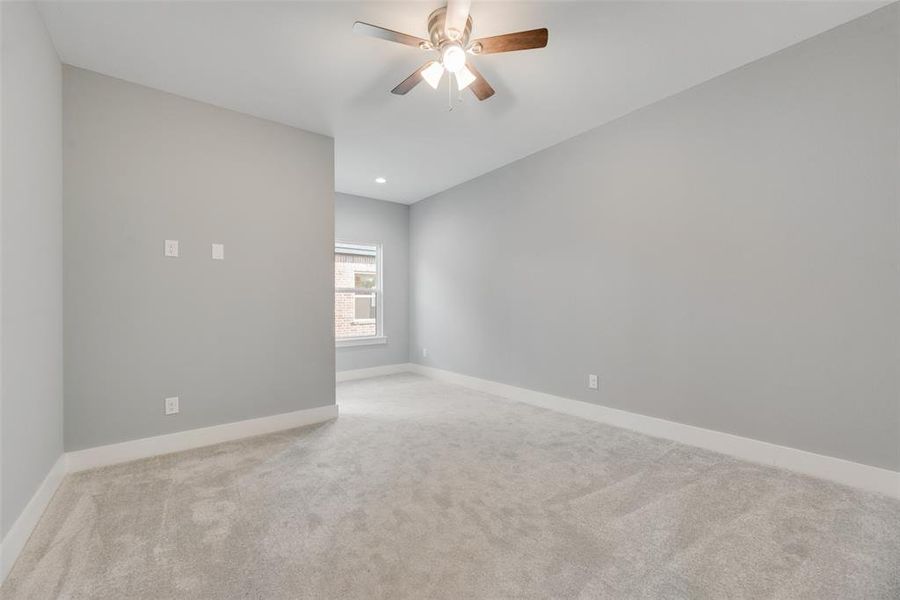 Empty room with light carpet and ceiling fan