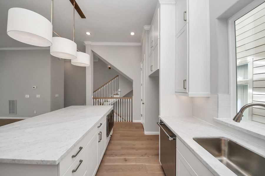Alternate view of the kitchen showcasing custom cabinetry, premium finishes, and open-concept design. Alternate view of the kitchen showcasing custom cabinetry, premium finishes, and open-concept design.