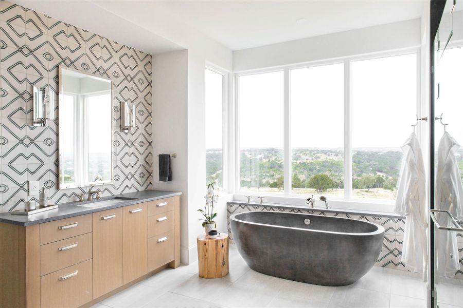 Full bathroom featuring vanity, a freestanding bath, and light tile patterned floors