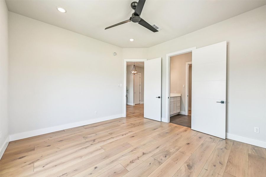 This view highlights the room’s seamless connection to its private full bath, combining elegance and convenience. Natural light illuminates the space, making it a serene and inviting personal retreat for mornings and evenings alike.