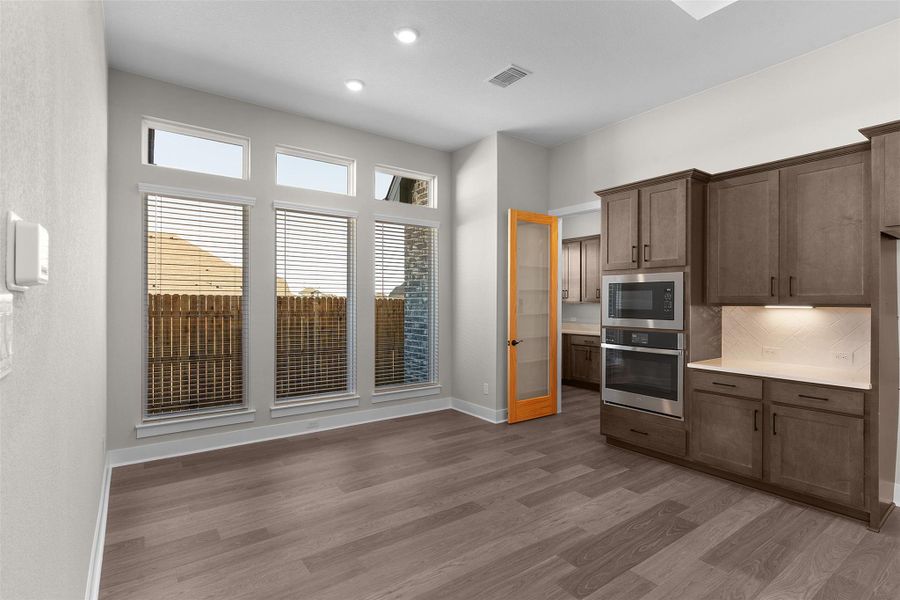 Kitchen featuring appliances with stainless steel finishes, tasteful backsplash, light wood-style floors, and recessed lighting