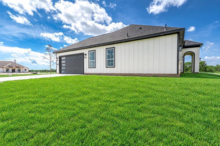 Side view of the home showcasing the garage and clean exterior design. Side view of the home showcasing the garage and clean exterior design.