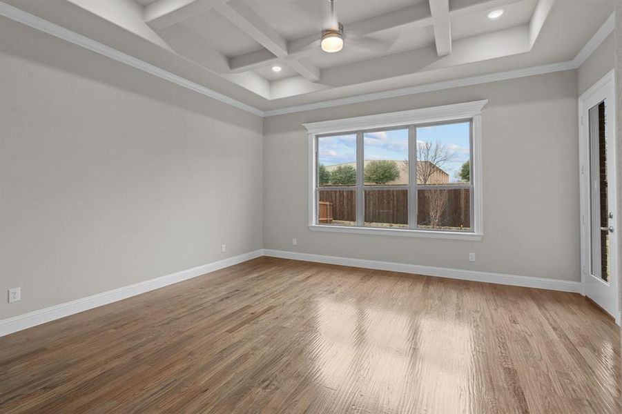 Spare room with coffered ceiling, hardwood / wood-style floors, ornamental molding, ceiling fan, and beam ceiling. Not actual home. Previous built example.