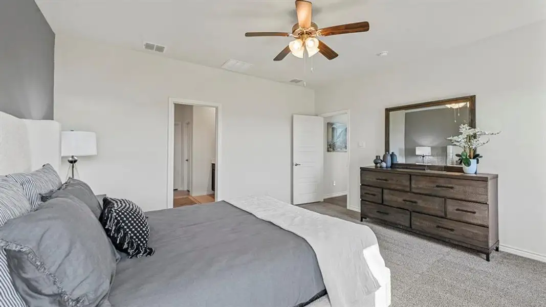 Spacious room featuring vaulted ceilings, a ceiling fan with integrated lighting, and light gray carpeting