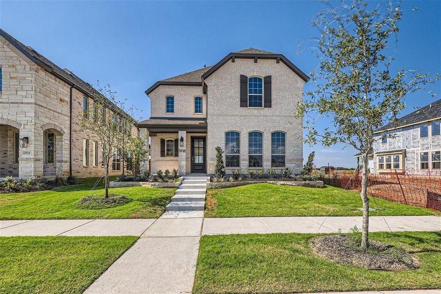 French country inspired facade featuring a porch and a front yard