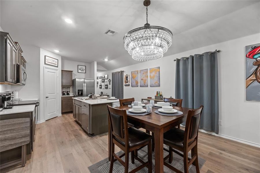 Dining area with light wood-type flooring, recessed lighting, a chandelier, and lofted ceiling