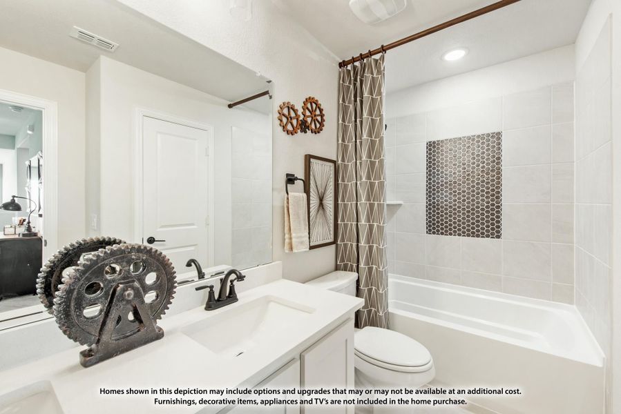 Bathroom with white vanity, tub-shower combo with tile surround, and patterned shower curtain