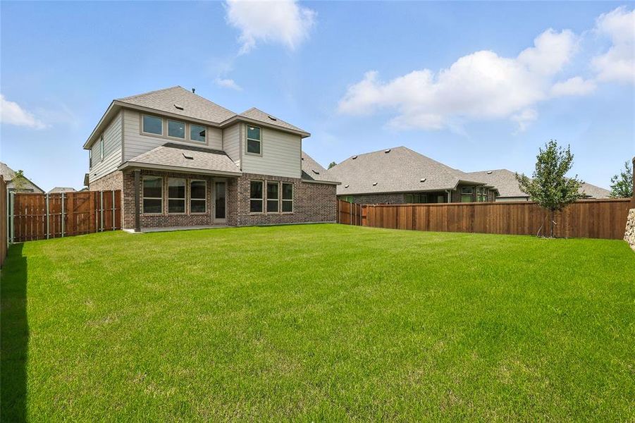 Rear view of house with brick siding, a fenced backyard, and a shingled roof Rear view of house with brick siding, a fenced backyard, and a shingled roof