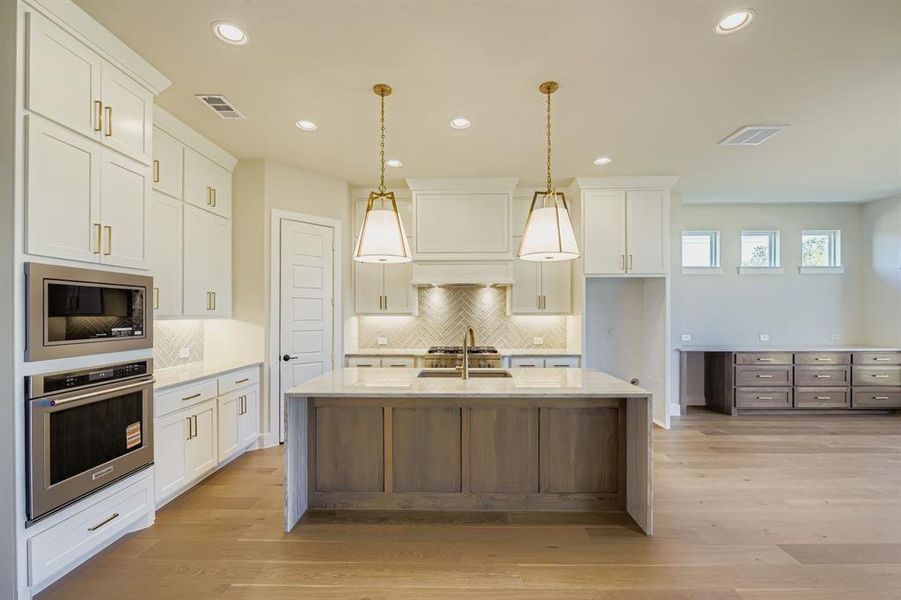 Kitchen with light stone counters, white cabinets, appliances with stainless steel finishes, decorative backsplash, and recessed lighting