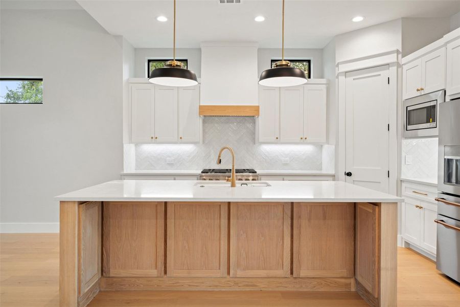 A central island anchors this bright kitchen, complete with a gas range and built-in appliances. A central island anchors this bright kitchen, complete with a gas range and built-in appliances.