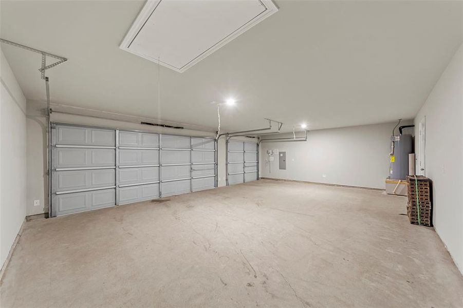 Garage featuring gas water heater and electric panel