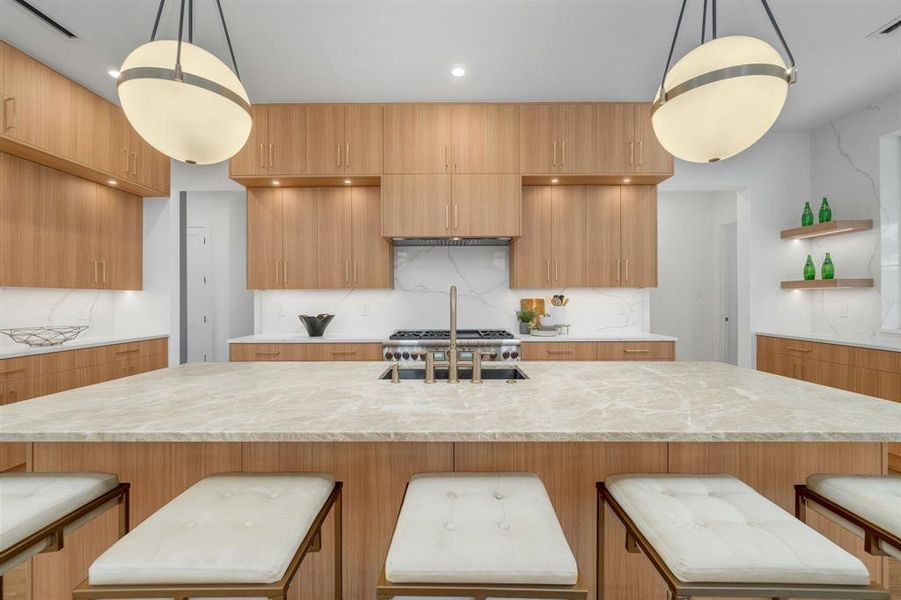 Kitchen with a kitchen breakfast bar, light stone counters, and open shelves Kitchen with a kitchen breakfast bar, light stone counters, and open shelves