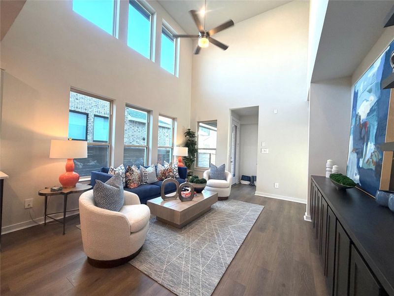 Your family room has two story windows, built in cabinetry and shelving with an open flow into the kitchen.