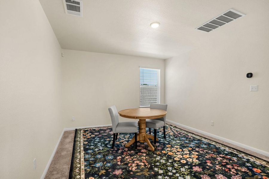 A quaint dining nook with a compact table offers a perfect spot for intimate meals.