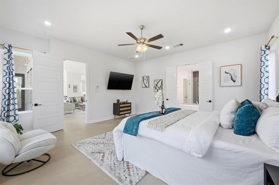 Spacious interior room featuring light wood-finish flooring, a contemporary ceiling fan, recessed lighting, and white paneled doors