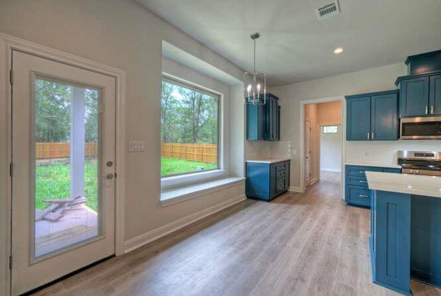 Kitchen with healthy amount of natural light, light wood-type flooring, appliances with stainless steel finishes, and recessed lighting