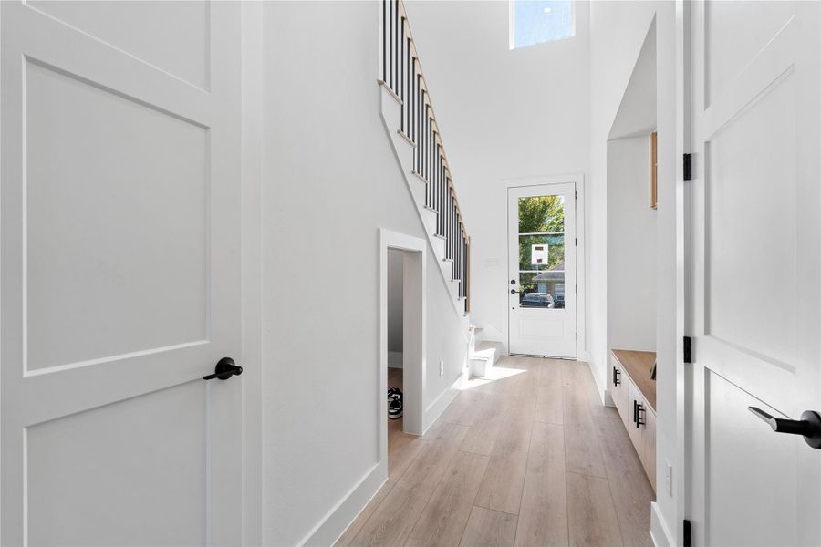 A dramatic vertical corridor defined by stair geometry and ceiling height, where natural light draws the eye forward and emphasizes the home’s layered spatial design.