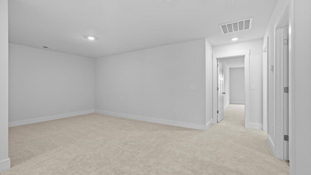 Refined loft with comfortable carpeted flooring and tasteful design throughout