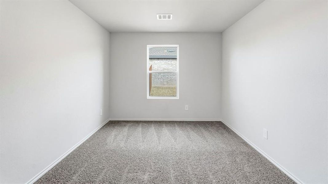 Room featuring light gray walls, gray patterned carpeting, and a window providing natural light Room featuring light gray walls, gray patterned carpeting, and a window providing natural light
