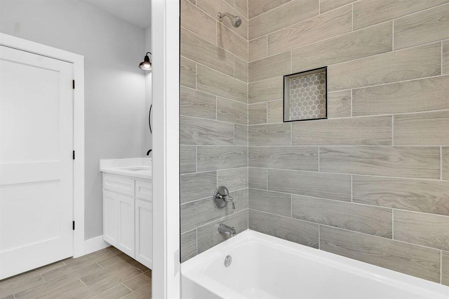 Full bathroom featuring  shower combination, wood finish floors, and vanity