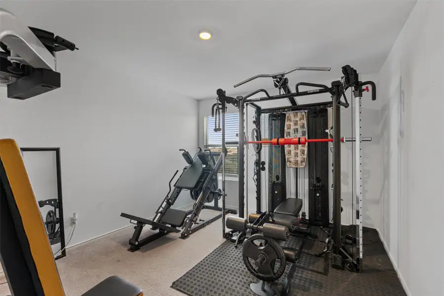Exercise room with carpet flooring and baseboards