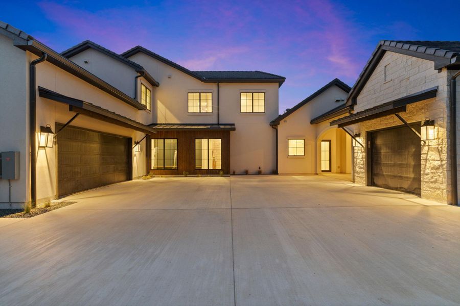 Motor court with 2 car garage connected to house and 1 car garage connected to porte-cochere.