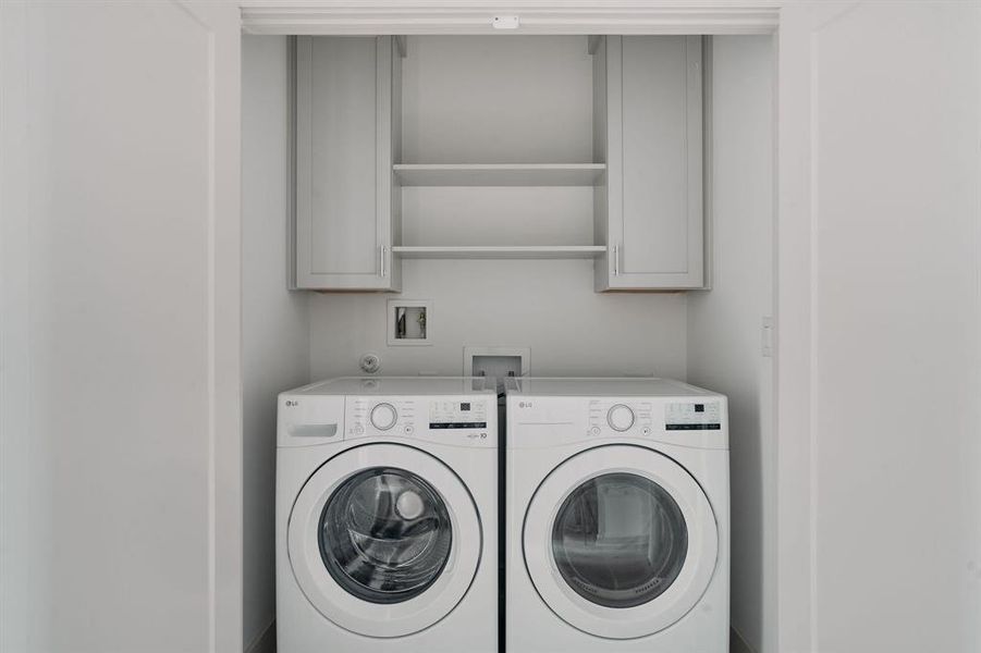 Dedicated laundry area featuring a white front-load washer and dryer set Dedicated laundry area featuring a white front-load washer and dryer set