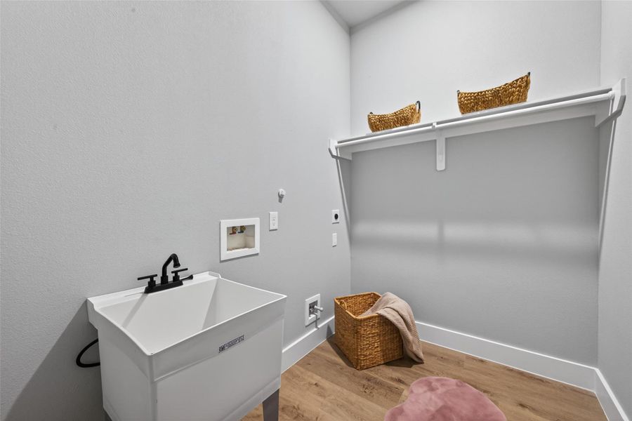 Spacious laundry room with utility sink and built-in shelving for added convenience.
